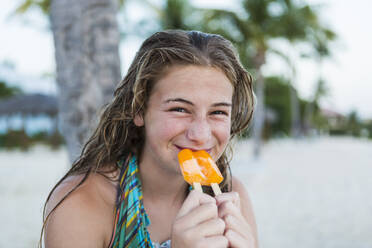 Ein junges Mädchen isst im Urlaub ein Eis am Stiel - MINF12786