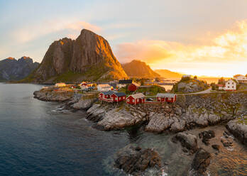 Rote Holzhütten, bekannt als Rorbu, im Dorf Reine auf der Insel Hamnoy, Lofoten. Rorbu ist ein traditionelles norwegisches Haus, das von Fischern genutzt wurde, heute werden die meisten von Touristen genutzt. - MINF12873