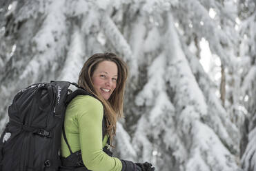 Porträt einer Frau beim Skifahren in den Bäumen am Stevens Pass, WA - CAVF68532