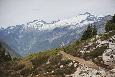 Eine Wanderin wandert auf einem Pfad im North Cascades National Park. - CAVF68538