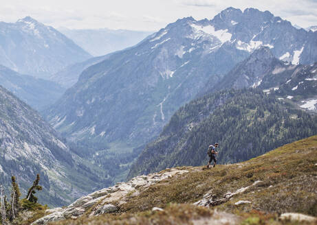 Ein männlicher Wanderer geht auf einem Wanderweg mit Aussicht in den Cascades, Washington - CAVF68539