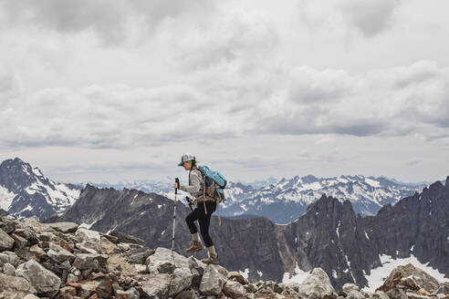 Eine Wanderin wandert inmitten der verschneiten Gipfel der Cascades, Washington - CAVF68540