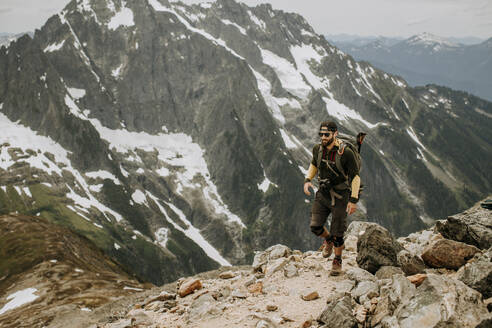 Ein männlicher Wanderer wandert auf einem Pfad in den North Cascades, Washington - CAVF68542