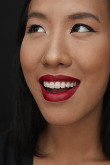 Portrait of young female Chinese woman with red lips, looking up - PGCF00067