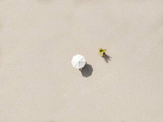 Luftaufnahme eines einzelnen Sonnenschirms am Sandstrand - KNTF03680