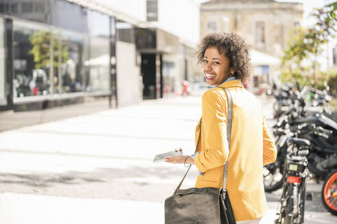 Portrait of happy young woman in the city - UUF19578