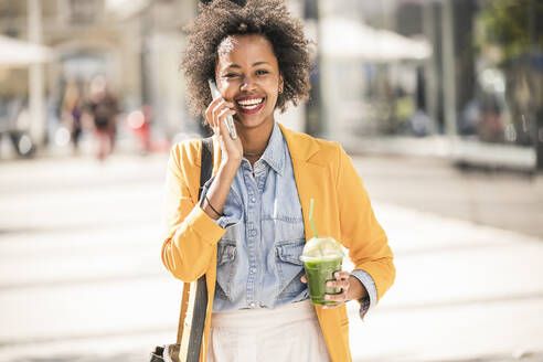 Happy young woman on the phone in the city - UUF19580