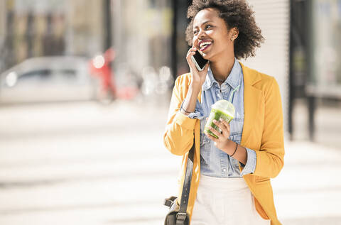 Glückliche junge Frau beim Telefonieren in der Stadt, lizenzfreies Stockfoto