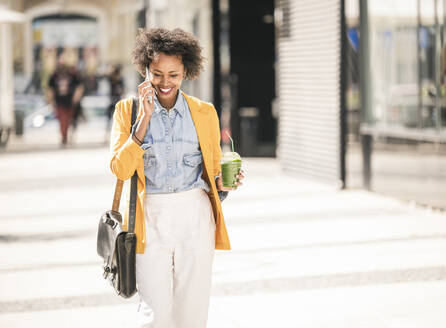 Happy young woman on the phone in the city - UUF19583