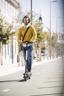 Young man riding e-scooter in the city - UUF19625