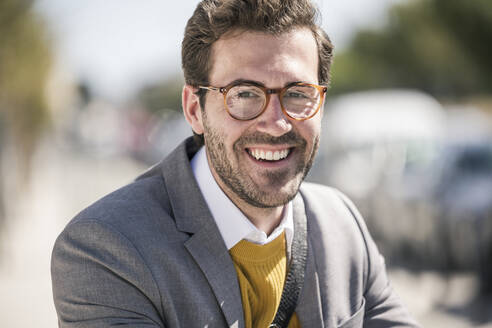 Portrait of smiling young businessman in the city - UUF19636