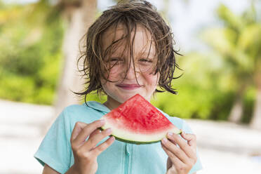 Smiling 5 year old boy eating watermelon slice - MINF12991