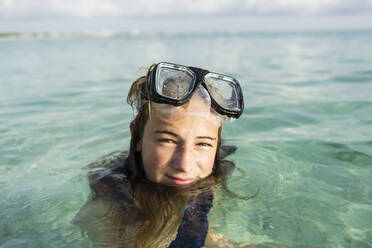 A teenage girl wearing snorkelling mask in the ocean - MINF13016