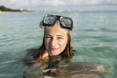 A teenage girl wearing snorkelling mask in the ocean - MINF13017