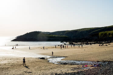 Badende an einem Sandstrand an der Küste von Pembrokeshire, Wales, UK. - MINF13040