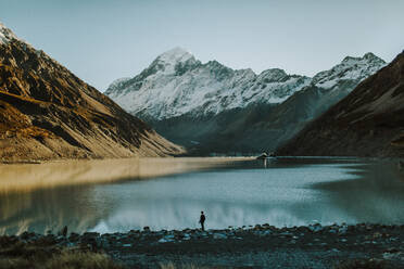 Männlicher Tourist betrachtet die Berge in Neuseeland während eines Sonnenausflugs - CAVF68579