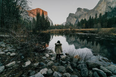 Female tourist in Yosemite looking at river against mountains - CAVF68582