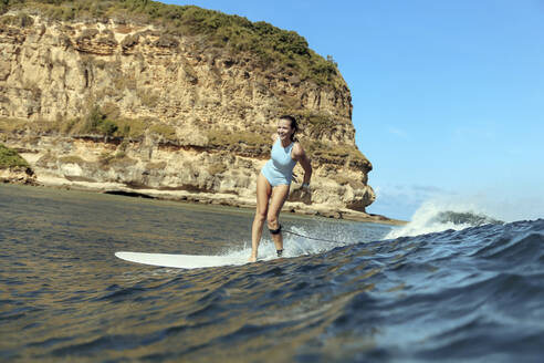 Lächelnde Frau beim Surfen - CAVF68645