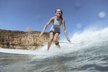 Lächelnde Frau beim Surfen - CAVF68648