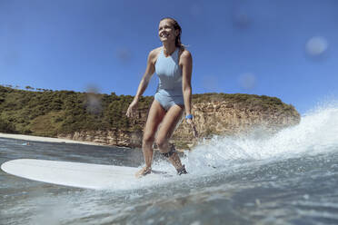 Smiling woman surfing - CAVF68649