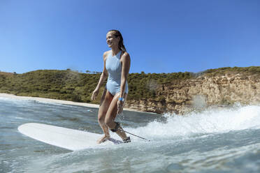 Lächelnde Frau beim Surfen - CAVF68650