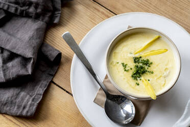 High angle close up of bowl of soup on wooden table. - MINF13161