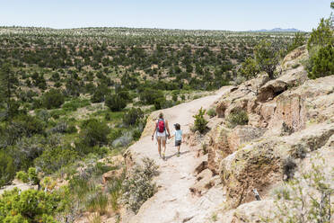 Mother and her 5 year old son walking on a path in the New Mexico desert - MINF13240