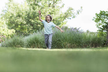 5 year old boy running on green lawn - MINF13256