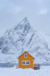 Lonely house with a sharp edged mountain in lofoten islands - CAVF68698