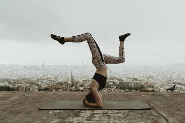 Junge Frau übt Yoga, Asana mit angehobenen Beinen, Barcelona. - CAVF68788
