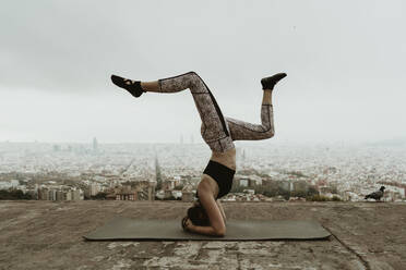 Junge Frau übt Yoga, hebt beide Beine im Kreuz. Barcelona - CAVF68795
