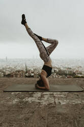 Junge Frau übt Yoga, Asana mit angehobenen Beinen, Barcelona - CAVF68797