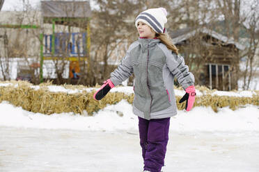 Kleines Mädchen lernt Schlittschuhlaufen im Freien - CAVF68883