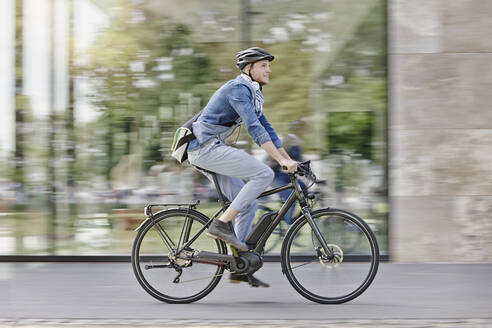 Student auf seinem E-Bike an der Goethe-Universität in Frankfurt, Deutschland - RORF01948