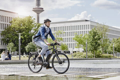 Student auf seinem E-Bike an der Goethe-Universität in Frankfurt, Deutschland, lizenzfreies Stockfoto