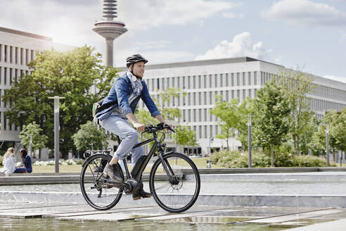 Student auf seinem E-Bike an der Goethe-Universität in Frankfurt, Deutschland - RORF01951