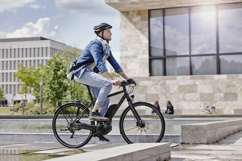 Student auf seinem E-Bike an der Goethe-Universität in Frankfurt, Deutschland - RORF01952