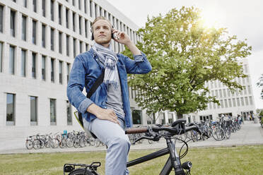 Student mit Kopfhörer und E-Bike - RORF01956