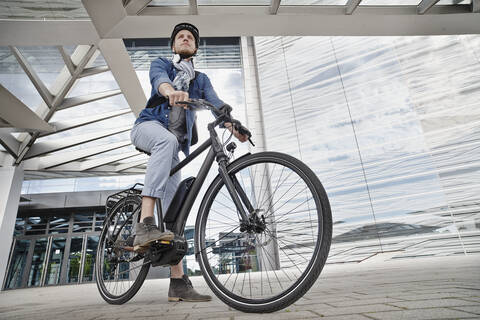 Student auf seinem E-Bike an der Goethe-Universität in Frankfurt, Deutschland, lizenzfreies Stockfoto