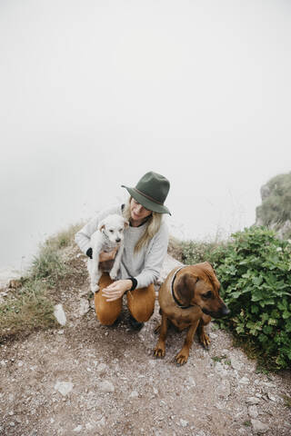 Junge Frau mit zwei Hunden auf Aussichtspunkt, lizenzfreies Stockfoto