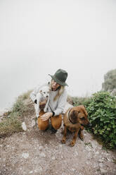 Young woman with two dogs on viewpoint - LHPF01134