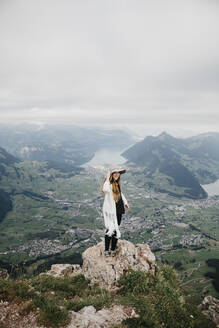 Junge Frau mit Hut, stehend auf Aussichtspunkt, Grosser Mythen, Schweiz - LHPF01138