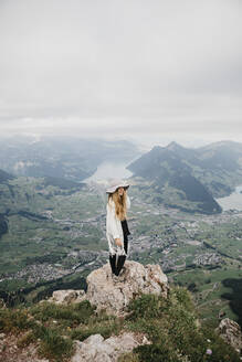 Young woman wearing hat, standing on viewpoint, Grosser Mythen, Switzerland - LHPF01139