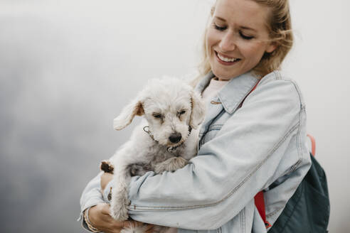 Young smiling female hiker with dog - LHPF01145