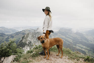 Woman with dog on viewpoint, Grosser Mythen, Switzerland - LHPF01147