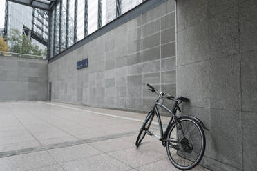 Black bicycle leaning against wall of station building at Potsdamer Platz, Berlin, Germany - AHSF01145