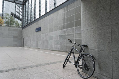 Schwarzes Fahrrad, das an der Wand des Bahnhofsgebäudes am Potsdamer Platz lehnt, Berlin, Deutschland - AHSF01145