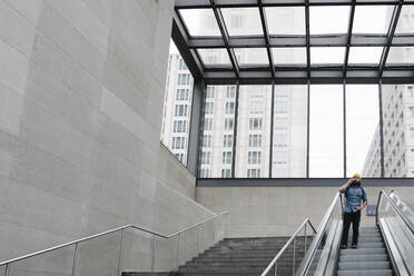 Man on the phone using escalator, Berlin, Germany - AHSF01153