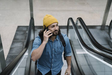 Porträt eines telefonierenden Mannes auf einer Rolltreppe - AHSF01155