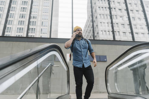 Mann telefoniert auf einer Rolltreppe, Berlin, Deutschland - AHSF01179